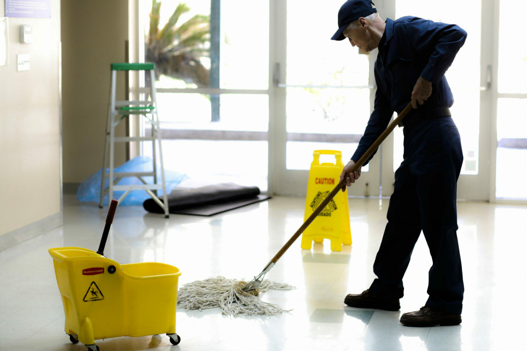 Full Length Image Of Senior Man Working As A Janitor In Building.